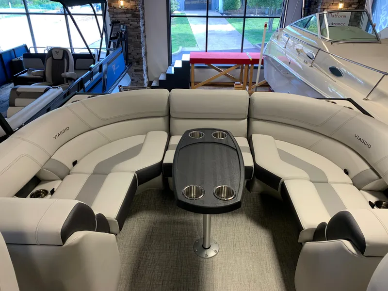 Slide: The Image of 2023 Viaggio Diamante 21U pontoon boat interior with plush seating and table. - 6