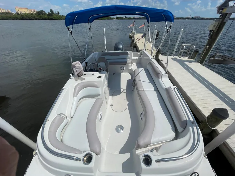 Slide: The Image of 2018 Starcraft 2000 OB Limited boat docked by the water with blue canopy. - 21