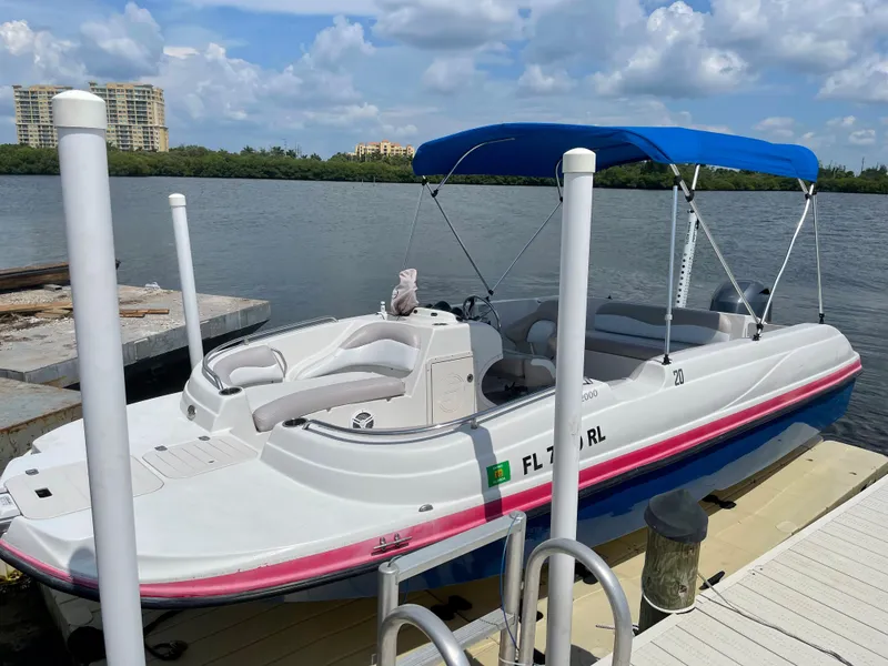 Slide: The Image of 2018 Starcraft 2000 OB Limited boat docked by a lake with blue canopy. - 3