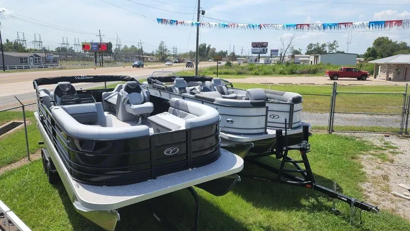 Slide: The Image of 2023 Veranda VISTA22RC Bi-Toon boats displayed outdoors on trailers. - 4