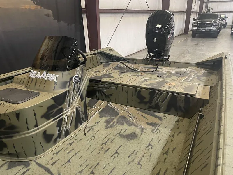 Slide: The Image of 2023 SeaArk RiverCat 200 Side Console boat in camouflage pattern, indoor storage. - 2