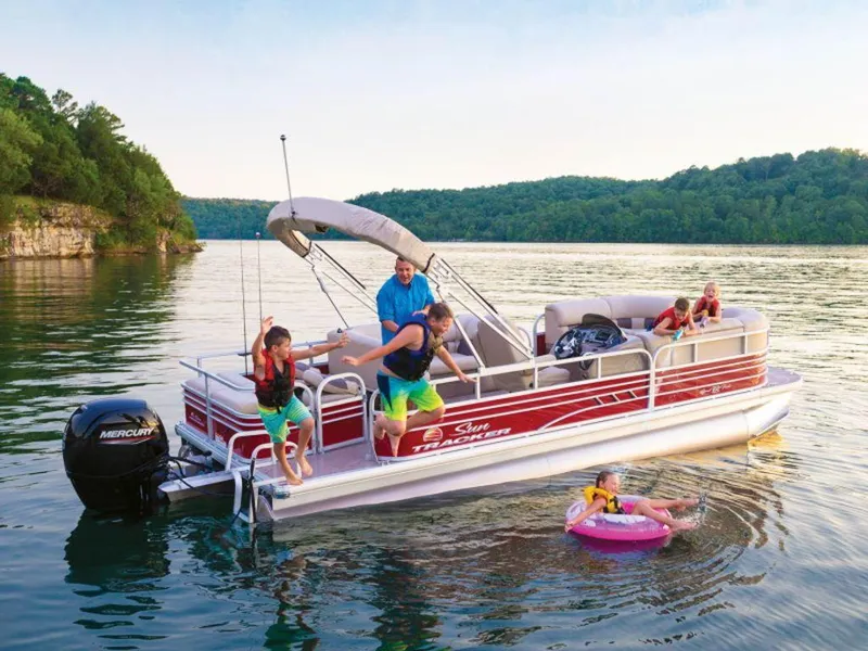 The Image of 2023 Sun Tracker SportFish™ 22 DLX pontoon boat with family enjoying water activities. - 1