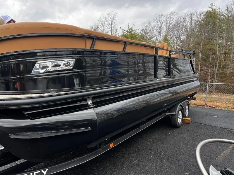Slide: The Image of 2023 Regency 250 LE3 pontoon boat on trailer, black and tan design. - 17
