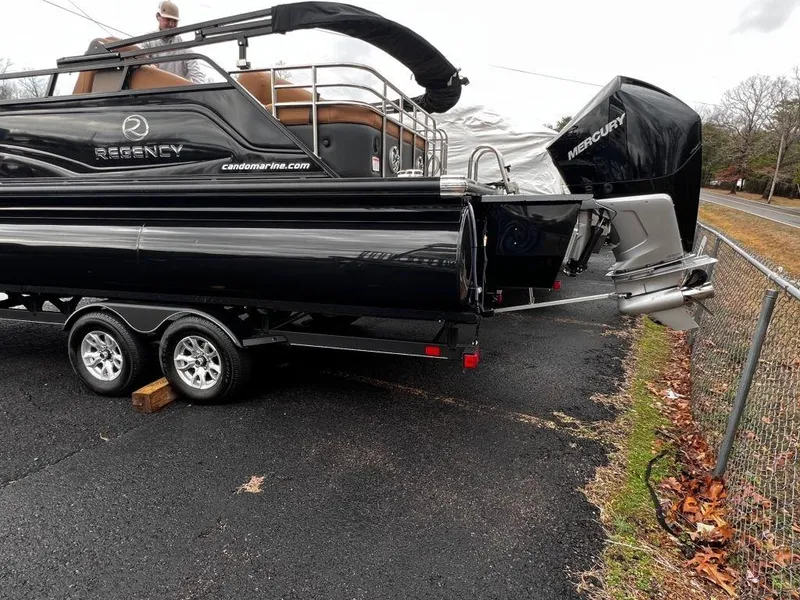 Slide: The Image of 2023 Regency 250 LE3 pontoon boat on trailer, black exterior, Mercury engine. - 19