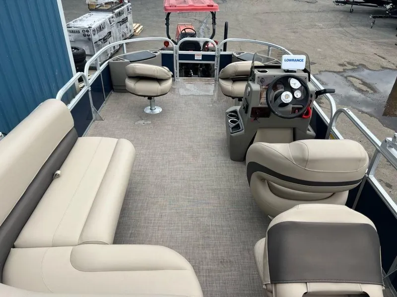 Slide: The Image of 2023 Sun Tracker BASS BUGGY® 18 DLX pontoon boat interior with beige seating and steering console. - 10