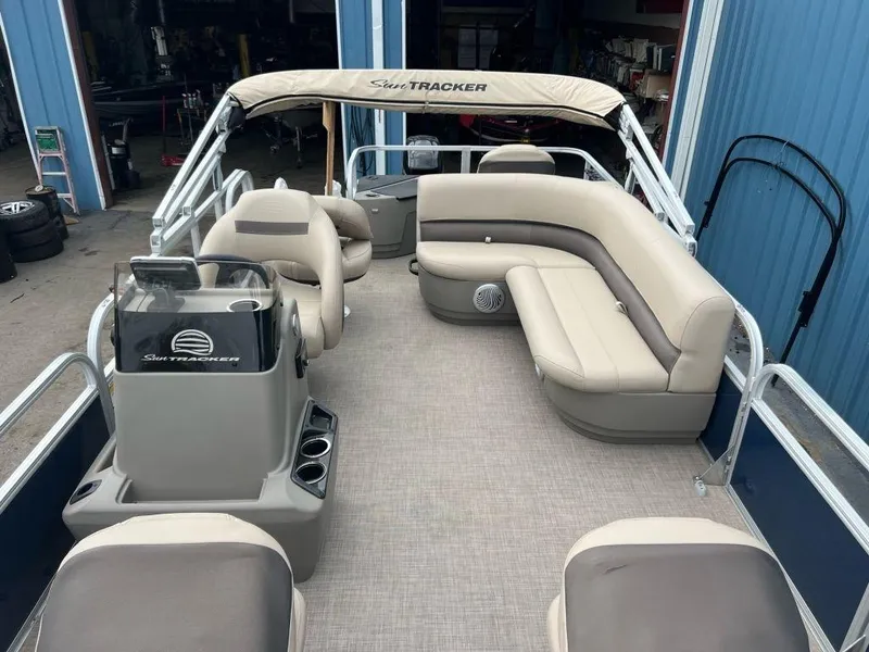 Slide: The Image of 2023 Sun Tracker BASS BUGGY® 18 DLX pontoon boat interior with beige seating and canopy. - 13