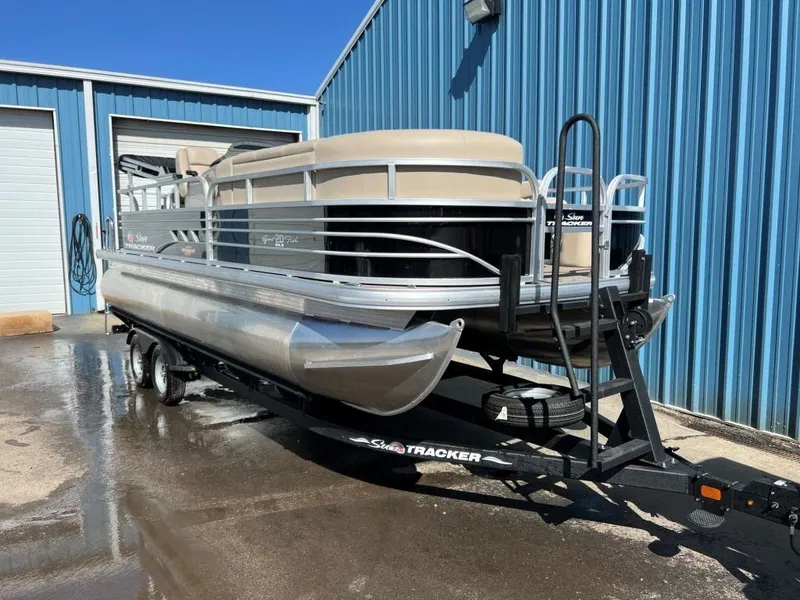Slide: The Image of 2023 Sun Tracker Sportfish™ 20 DLX pontoon boat on trailer outside blue building. - 8