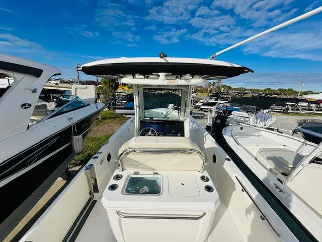Slide: The Image of 2023 Boston Whaler 280 Dauntless boat, center console view, docked under a clear blue sky. - 14