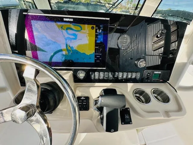Slide: The Image of 2023 Boston Whaler 280 Dauntless dashboard with Simrad navigation system and steering wheel. - 18