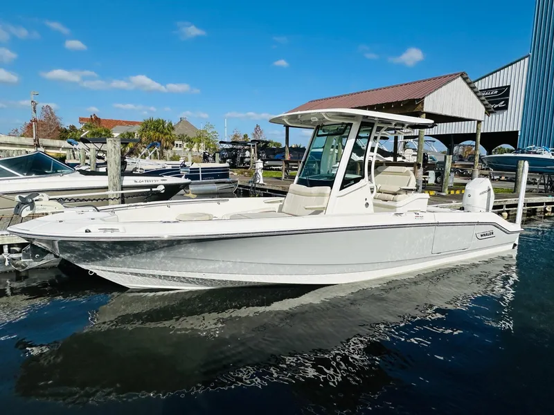 Slide: The Image of 2023 Boston Whaler 280 Dauntless boat docked at a marina on a sunny day. - 2