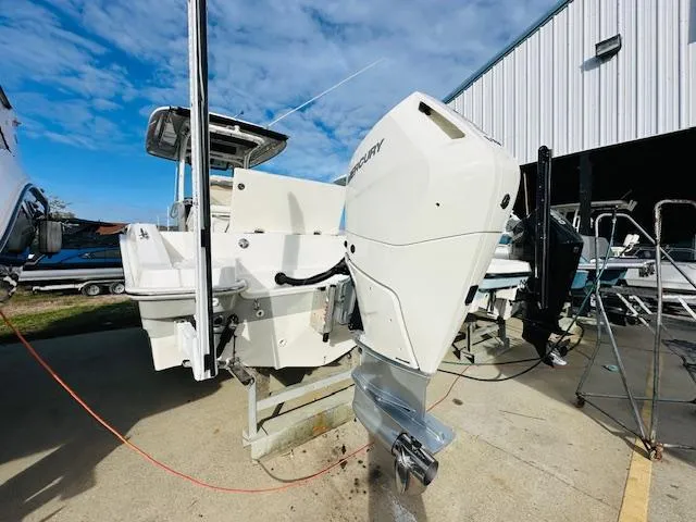 Slide: The Image of 2023 Boston Whaler 280 Dauntless boat with Mercury outboard engine, docked near a warehouse. - 6