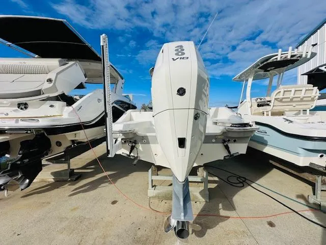 Slide: The Image of 2023 Boston Whaler 280 Dauntless boat with powerful outboard engine, docked under clear skies. - 7