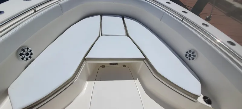 Slide: The Image of 2015 Robalo R300 Center Console boat bow seating area with white cushions. - 12