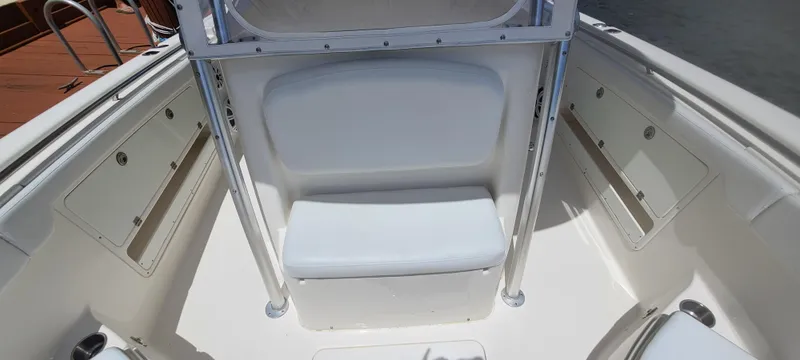 Slide: The Image of 2015 Robalo R300 Center Console boat seating area with white cushioned bench. - 18