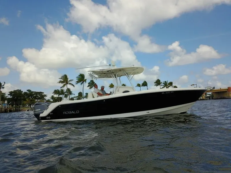 Slide: The Image of 2015 Robalo R300 Center Console boat on water with palm trees in background. - 35