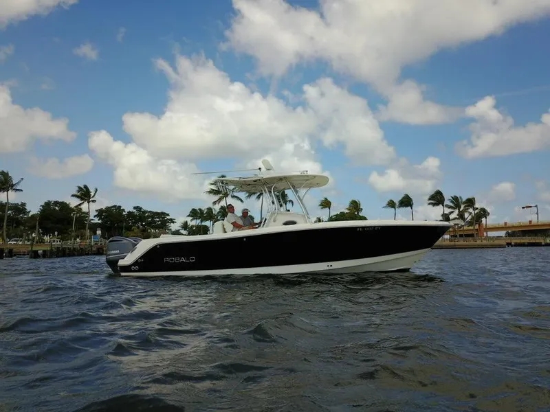 Slide: The Image of 2015 Robalo R300 Center Console boat on water with palm trees in background. - 36