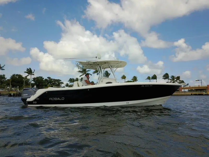 Slide: The Image of 2015 Robalo R300 Center Console boat on water with palm trees in background. - 37