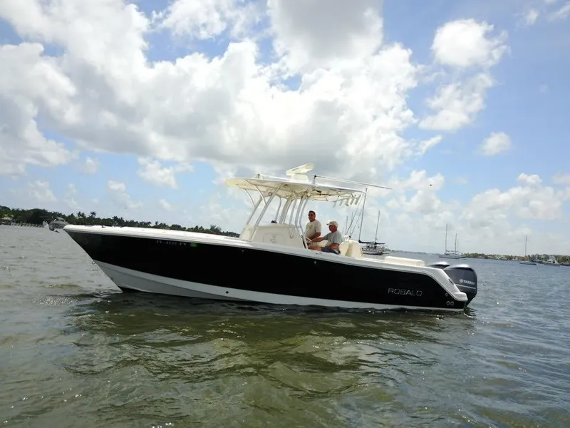 Slide: The Image of 2015 Robalo R300 Center Console boat on water under cloudy sky. - 40