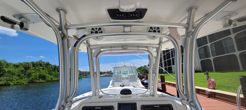 Slide: The Image of 2015 Robalo R300 Center Console boat docked by a scenic waterway. - 5