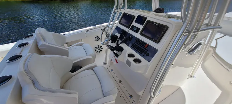 Slide: The Image of 2015 Robalo R300 Center Console boat interior with dual seats and control panel. - 8
