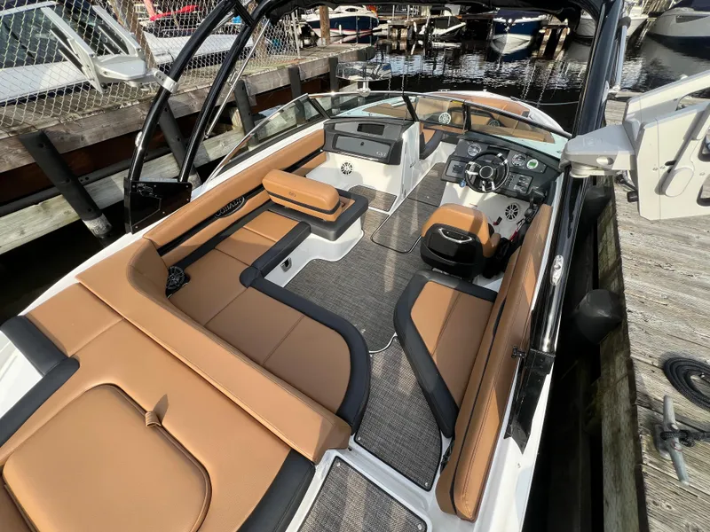 Slide: The Image of 2023 Cobalt CS23 Surf boat interior with tan seating and modern dashboard. - 10