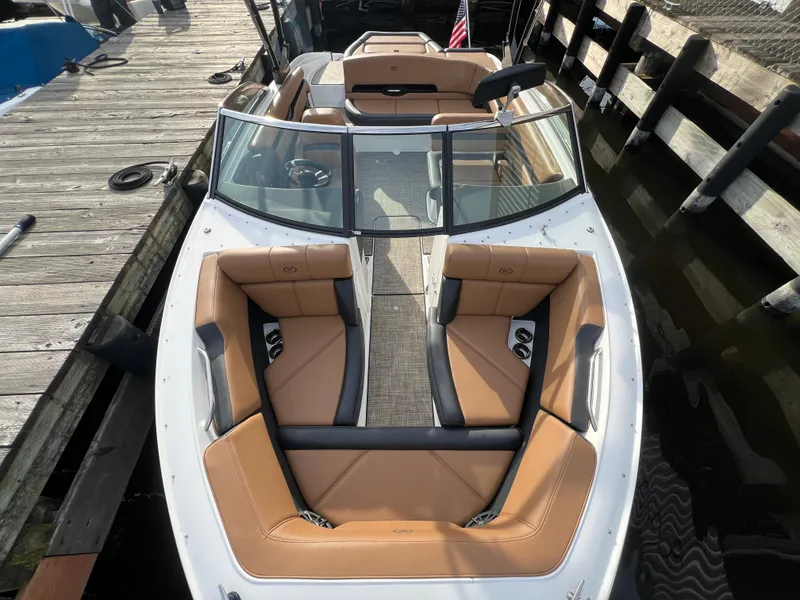 Slide: The Image of 2023 Cobalt CS23 Surf boat with tan seating, docked at a wooden pier. - 20