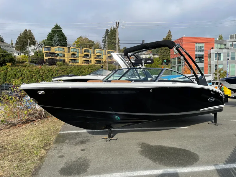 Slide: The Image of 2023 Cobalt CS23 Surf boat displayed outdoors in a parking area. - 22