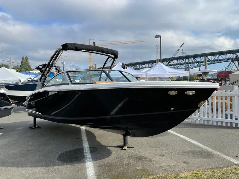 Slide: The Image of 2023 Cobalt CS23 Surf boat displayed outdoors with overcast sky. - 24