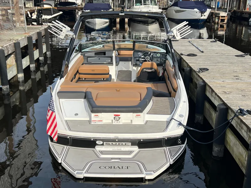 Slide: The Image of 2023 Cobalt CS23 Surf boat docked, featuring sleek design and comfortable seating. - 5