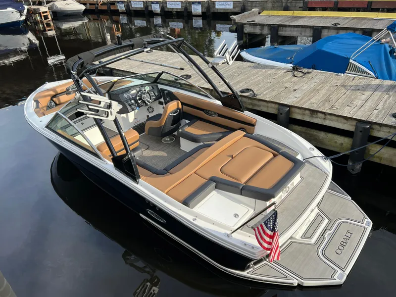 Slide: The Image of 2023 Cobalt CS23 Surf boat docked, featuring sleek design and comfortable seating. - 7