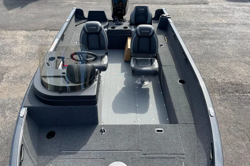 Slide: The Image of 2025 Lund 1650 Rebel XL SS fishing boat interior with seating and steering console. - 2