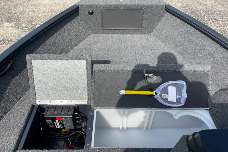 Slide: The Image of 2025 Lund 1650 Rebel XL SS boat interior with storage compartments and fishing net. - 5