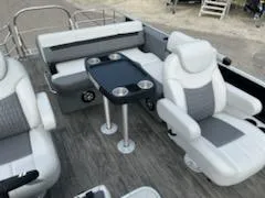 Slide: The Image of 2023 Sweetwater 2286SFL pontoon boat interior with plush seating and table. - 2