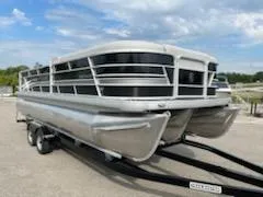Slide: The Image of 2023 Sweetwater 2286SFL pontoon boat on a trailer under a partly cloudy sky. - 4