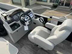 Slide: The Image of 2023 Sweetwater 2286SFL boat cockpit with steering wheel and captain's chair. - 7