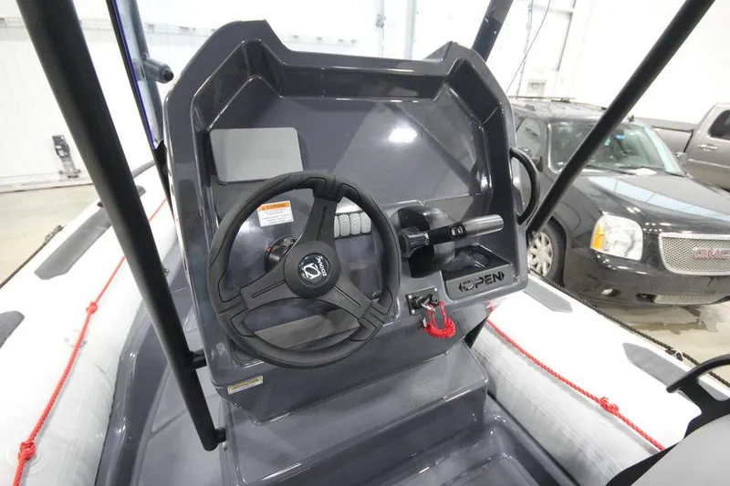 Slide: The Image of 2023 Zodiac Open 5.5 PVC boat interior with steering wheel and seating. - 10