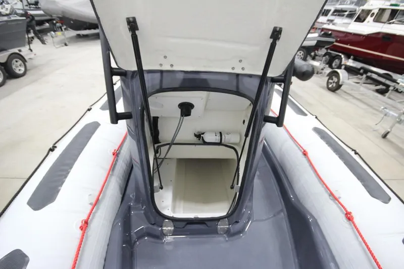 Slide: The Image of 2023 Zodiac Open 5.5 PVC boat interior with storage compartment and T-Top. - 15