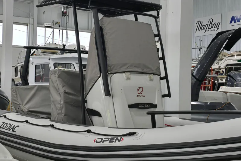 Slide: The Image of 2023 Zodiac Open 5.5 PVC boat with T-Top, covered seats, and 115hp engine in stock. - 21