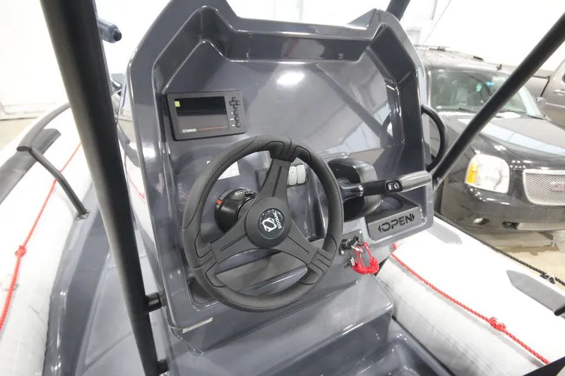 Slide: The Image of 2023 Zodiac Open 5.5 PVC boat with T-Top, docked at a marina. - 12