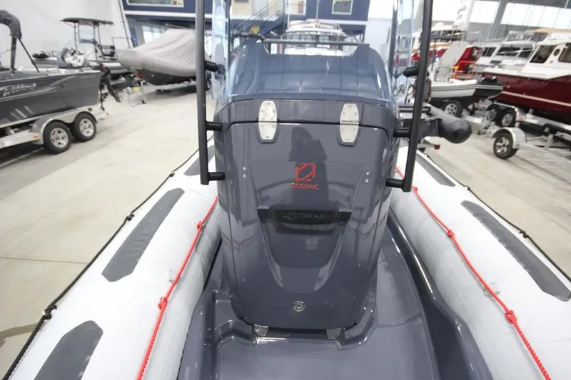 Slide: The Image of 2023 Zodiac Open 5.5 PVC boat with T-Top, docked in a marina. - 14