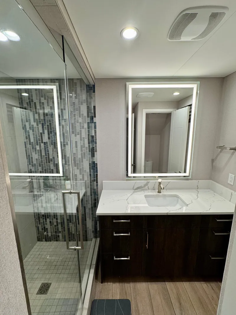 Slide: The Image of Modern RV bathroom with glass shower, illuminated mirror, and sleek vanity. Adonia Pace Trip #7, 2021 model. - 20