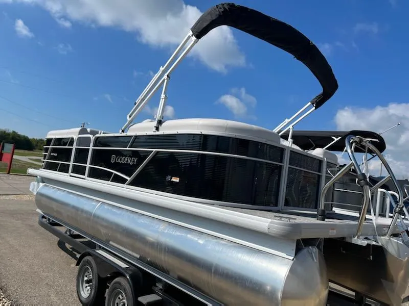 Slide: The Image of 2023 Sweetwater 2286SBCX pontoon boat on trailer under blue sky. - 2