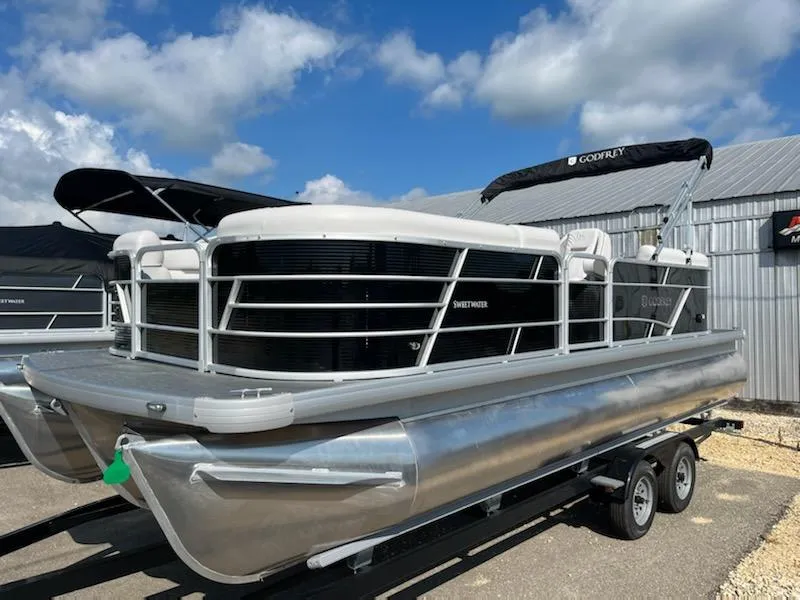 Slide: The Image of 2023 Sweetwater 2286SBCX pontoon boat on trailer under blue sky. - 3