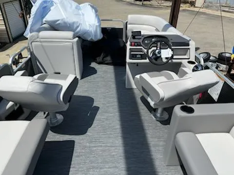 Slide: The Image of 2023 Sweetwater 2286SBCX pontoon boat interior with gray seating and steering console. - 9