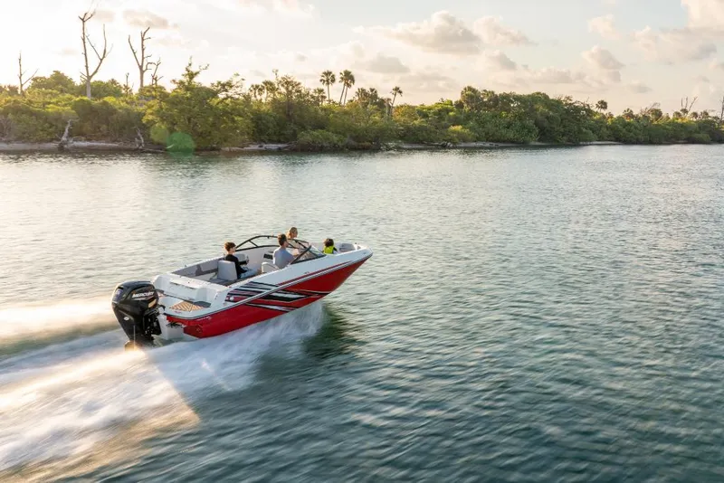 Slide: The Image of 2023 Bayliner M17 boat cruising on a serene lake with lush greenery in the background. - 16