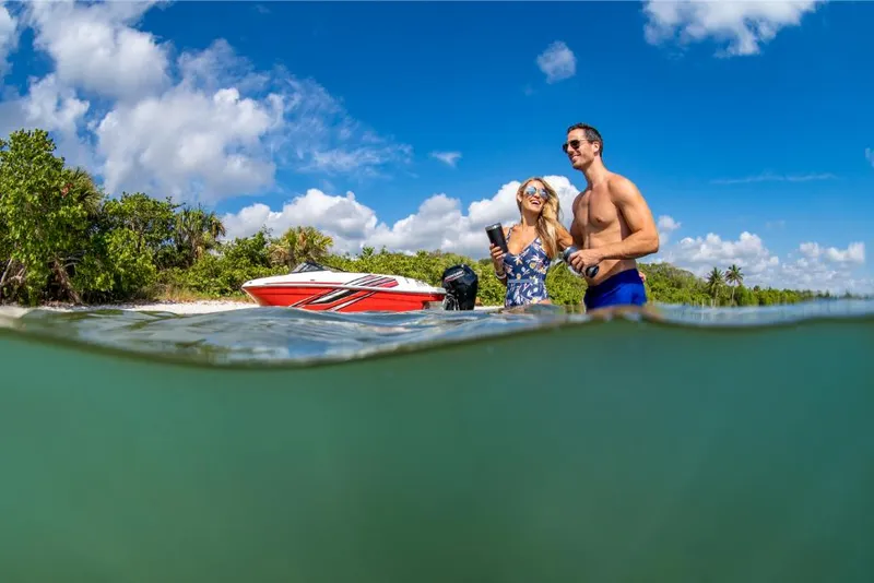 Slide: The Image of Couple enjoying a day by their 2023 Bayliner M17 boat in clear waters. - 22