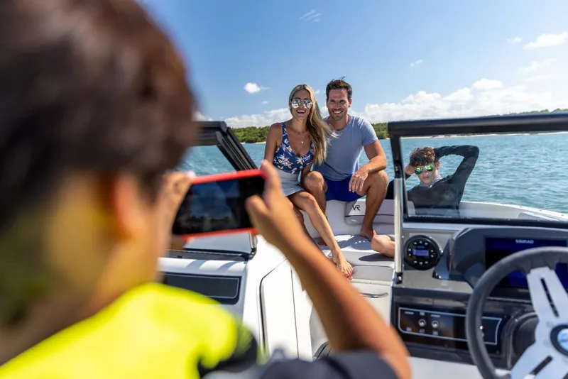 Slide: The Image of Family enjoying a day on a 2023 Bayliner M17 boat, posing for a photo. - 32