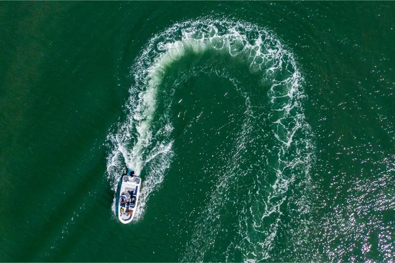 Slide: The Image of Aerial view of 2023 Bayliner M17 boat making a sharp turn in green water. - 36
