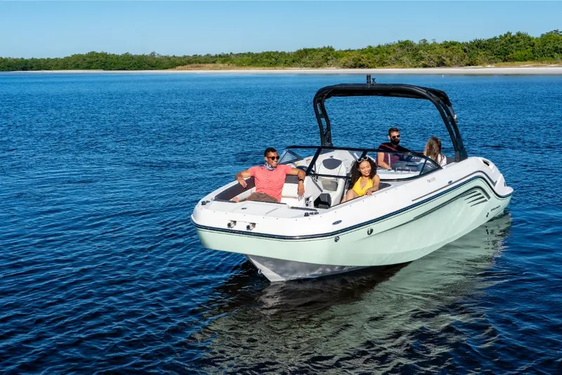 Slide: The Image of 2023 Bayliner DX2000 boat cruising on a serene lake with passengers. - 12