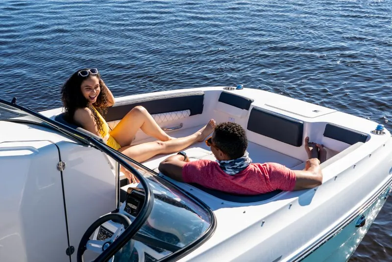 Slide: The Image of Couple relaxing on a 2023 Bayliner DX2000 boat on the water. - 13